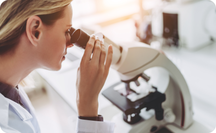 Scientific Womand observes a microscope